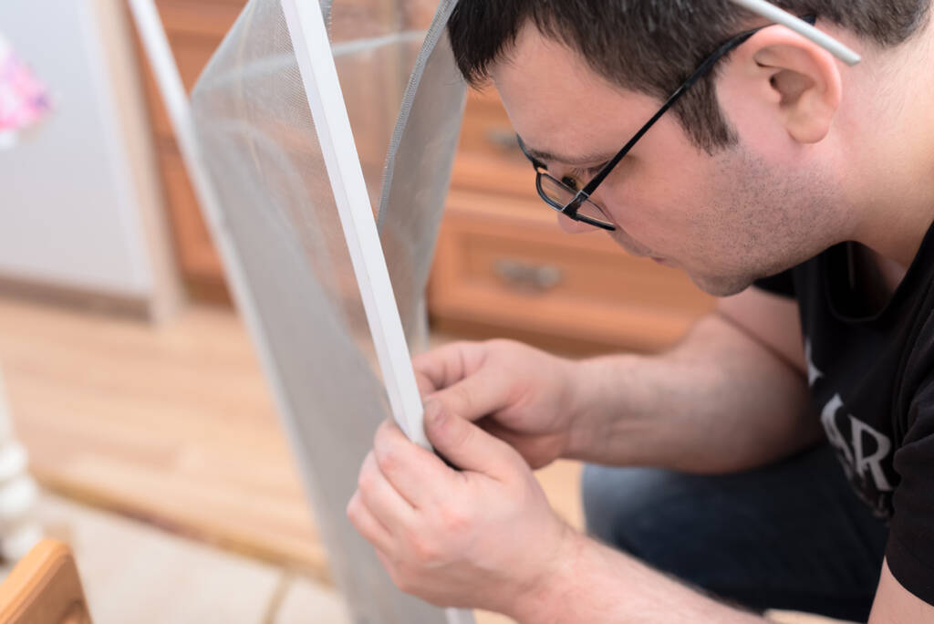 man repairing mosquito net window screen repair near me