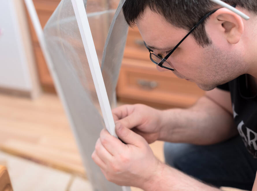 man repairing mosquito net window screen repair near me